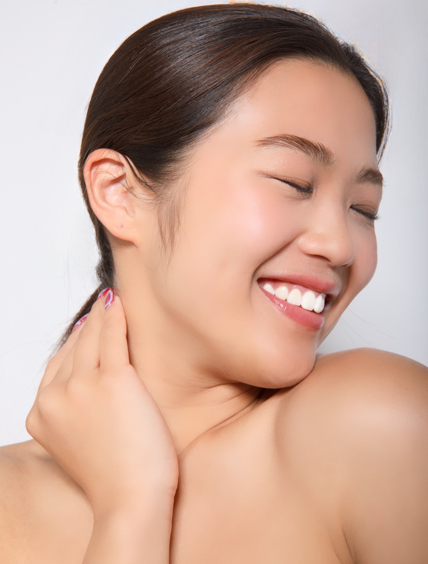 Dame Jo! model with smooth skin touching her neck against a white backgroundm basking in the goodness of Executive Radiance Serums.