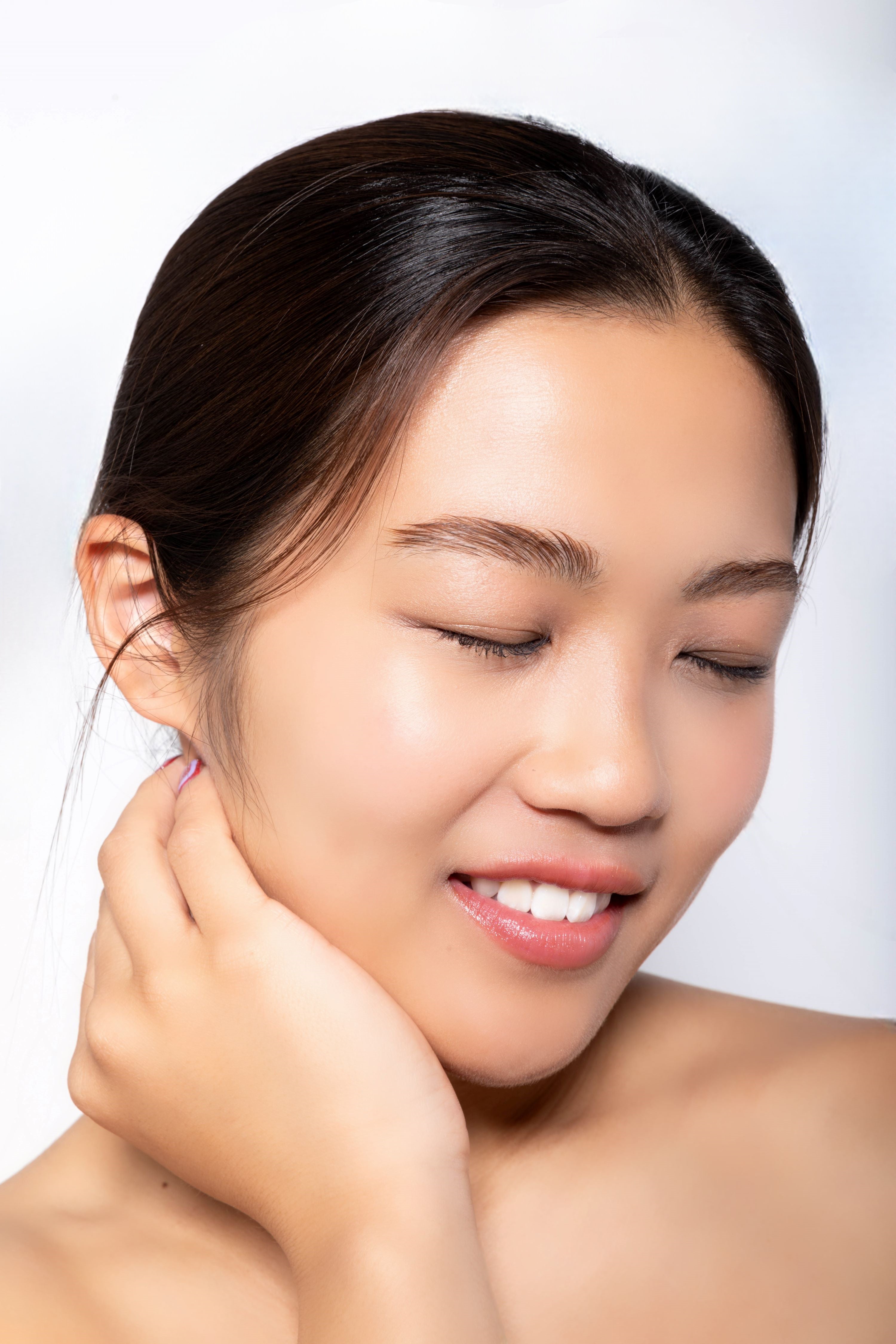 Model applying Executive Radiance serum with soft lighting and natural backdrop.