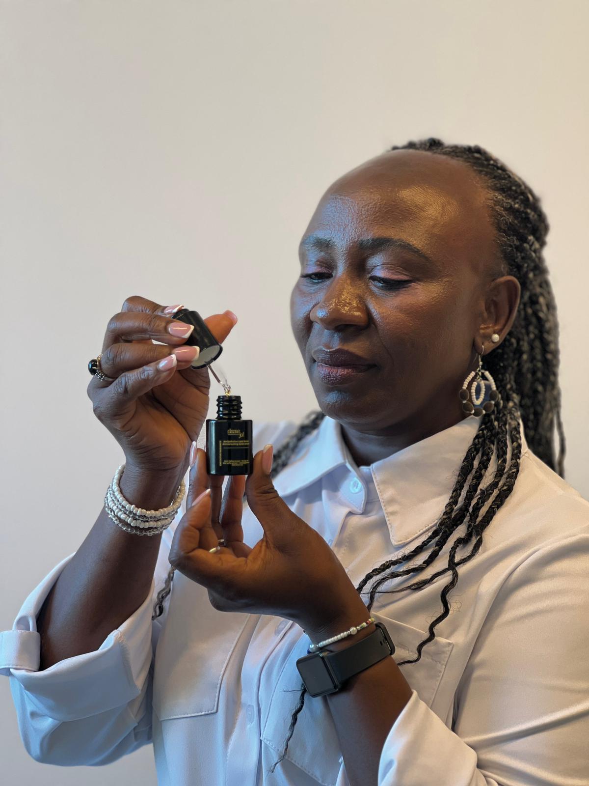 A woman using a dropper to apply Dame Jo! Executive Radiance Antipollution Lipid Serum near her eye area, holding the elegant black bottle; showcasing a nourishing daily skincare ritual for glow, hydration, and pollution defence.